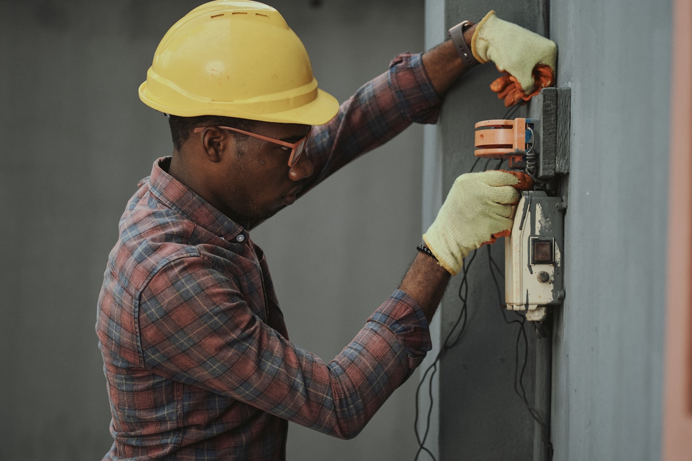 Electrician working inside an electrical service panel